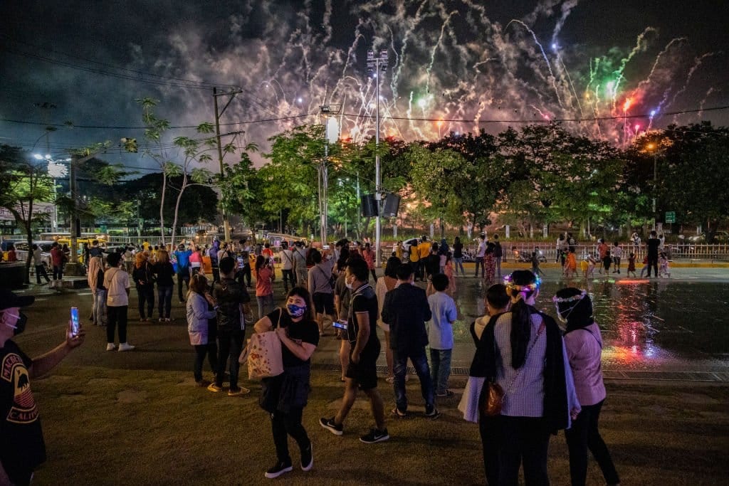 People gather in Manila to watch a fireworks display from a park