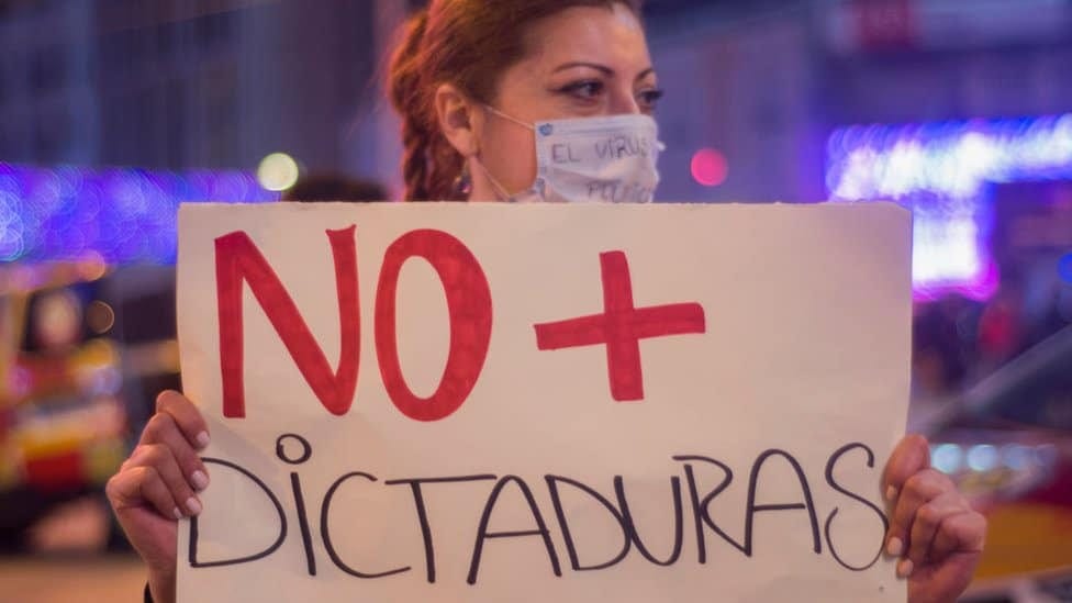 Woman in Madrid protesting with sign reading 