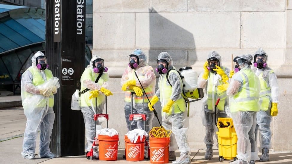 Cleaning workers in hazmat gear