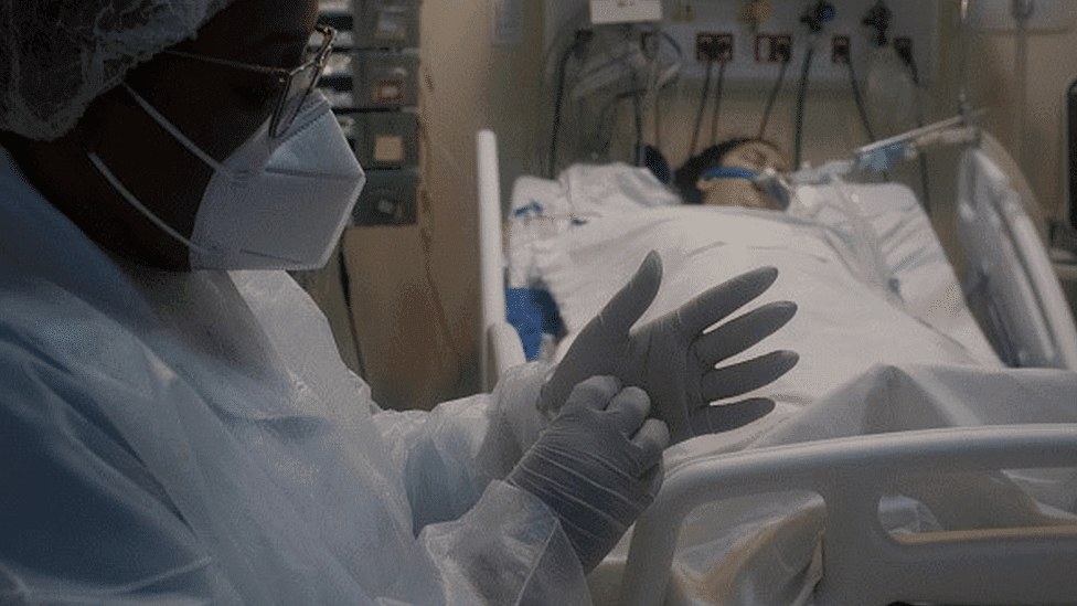 A healthcare professional takes care of a patient who is on a respirator